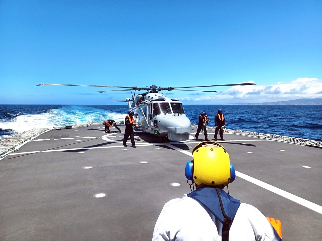 Helicóptero Lynx em cima do navio com 5 militares à volta 